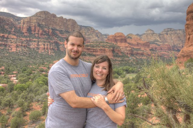 Couple Embracing Amid Sedona's Dramatic Red Rock Landscape