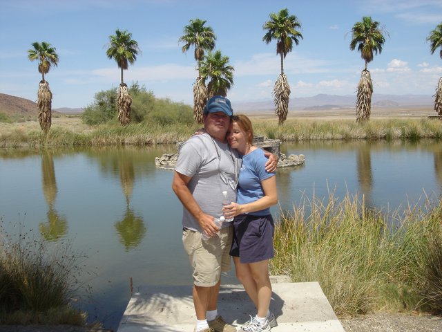 Couple Embracing at Desert Oasis Pond