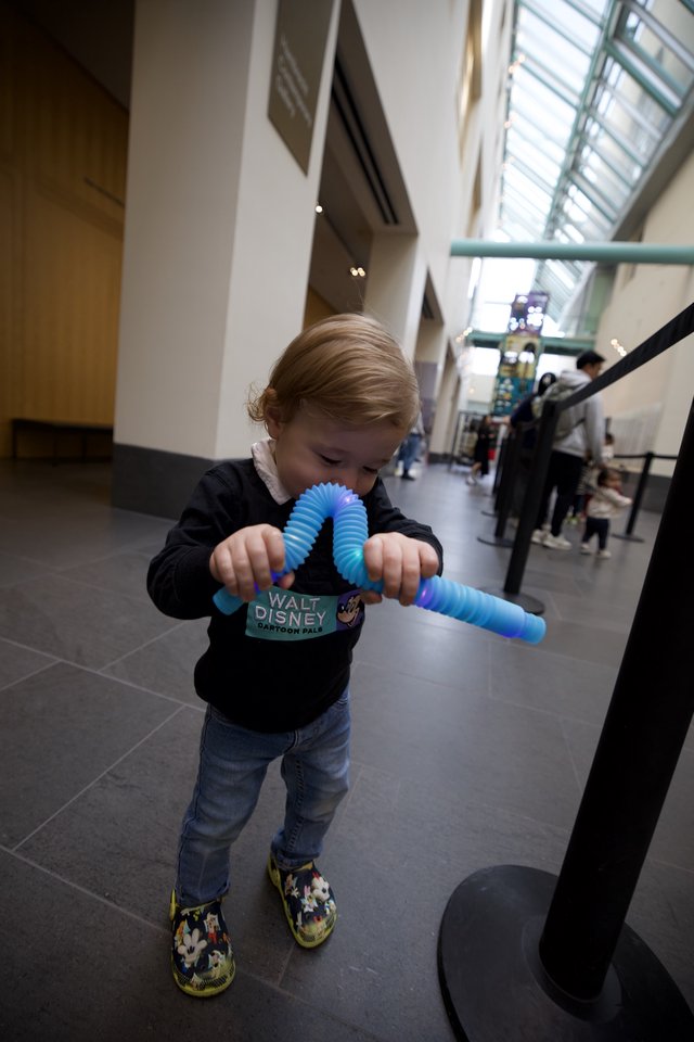 Toddler Playing with Blue Fidget Toy at Museum