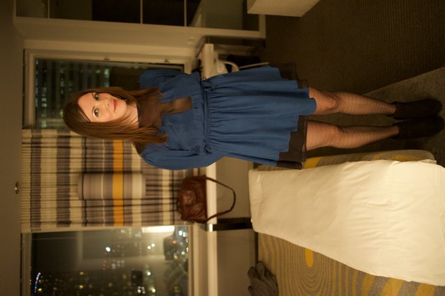 Woman in Blue Dress Poses in Hotel Room