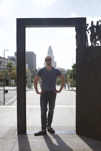 Man Standing in Front of City Sculpture