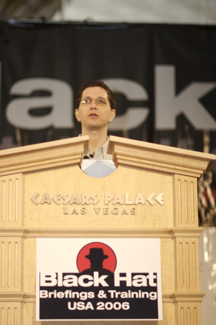 Jeff M delivering a speech in front of Black Hat sign