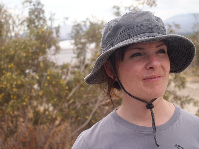 Woman in Sun Hat Gazes Across Desert Landscape