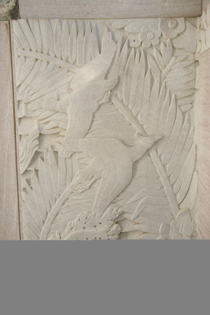 Intricate Carving of a Bird and Palm Leaves