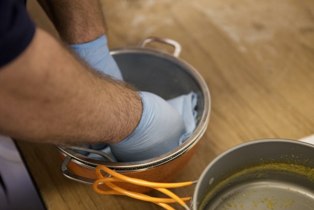 Cleaning a Pot with Blue Gloves