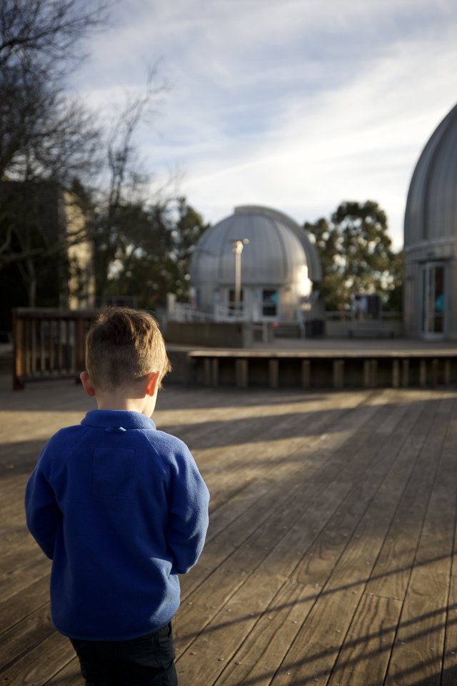 Young Boy Gazing at Observatory Domes at Dusk