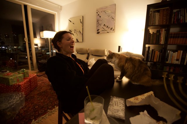Laughing Woman and Cat Share a Cozy Evening