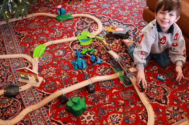 Young Boy Playing with Wooden Train Set on Christmas