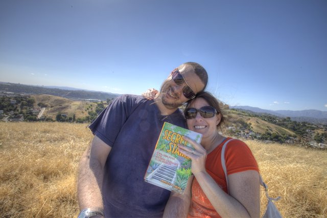 Couple Smiling Atop Los Angeles Hills with Guidebook