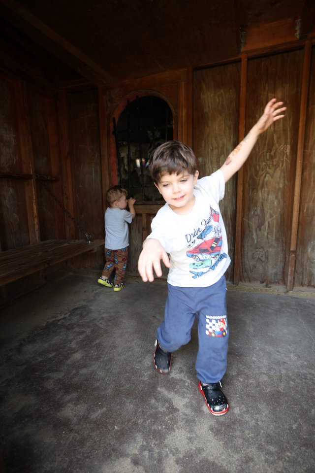 Young Boy Dancing in Rustic Wooden Room