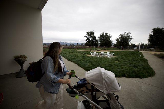 Mother with Stroller Walking Under Covered Patio at Dusk