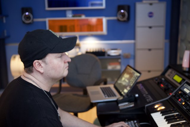 Man in Black Hat Working on Computer