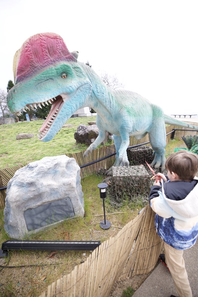 Child Confronts Colorful Spinosaurus at Dinosaur Park