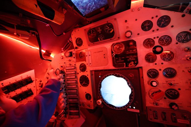 Inside a Vintage Spacecraft Control Module Under Red Lighting