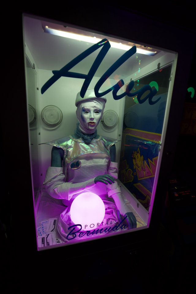 Futuristic Alien Fortune Teller Display in Retro Arcade Booth