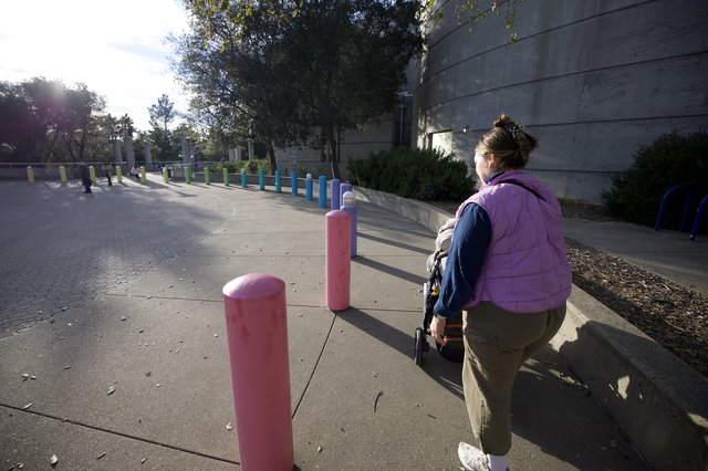 Parent and Child Exploring Colorful Bollard Installation