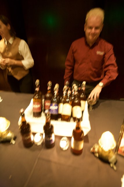 Man Behind Bar Table with Bottles of Alcohol