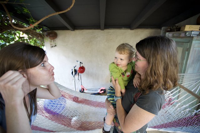 Two Women Delight in Baby's Cheek Kisses