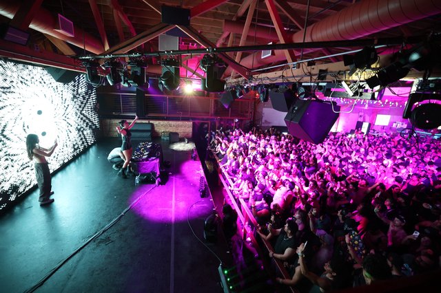 Packed Dance Crowd Pulses Under Violet Stage Lights