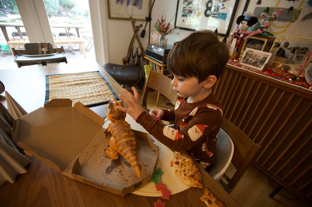 Young Boy's Delighted Dinosaur Pizza Discovery on Christmas
