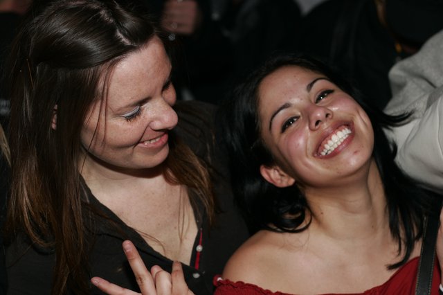 Two Friends Laughing Together at a Nighttime Event