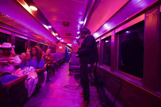 Live Music Performance in Purple-Lit Vintage Train Car