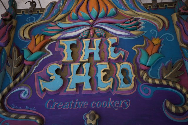 Colorful Hand-Carved Shed Sign with Ornate Design