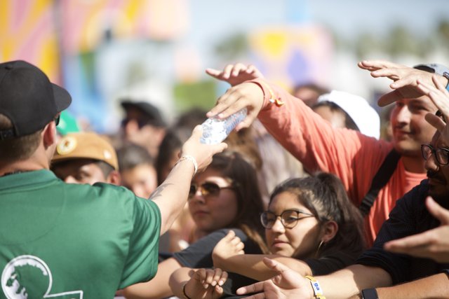 Man giving water to thirsty Coachella crowd