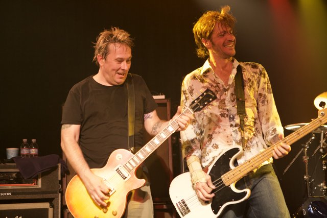 Two Men Jamming on Stage with Guitars