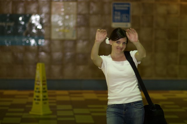 Playful Woman Raising Hands in Transit Station