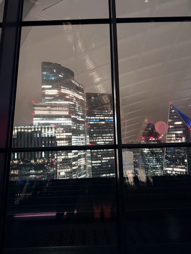London Financial District Skyline at Night Through Window