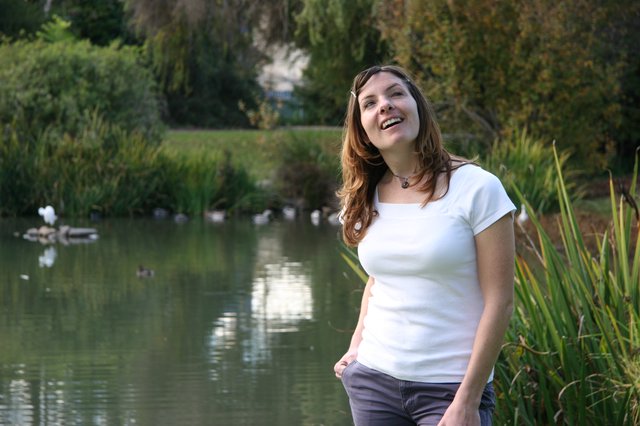 Joyful Woman Laughing by a Tranquil Park Pond