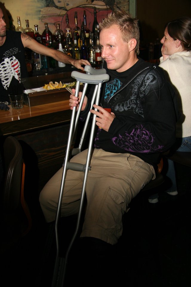 Man on Crutches Relaxing at a Bar