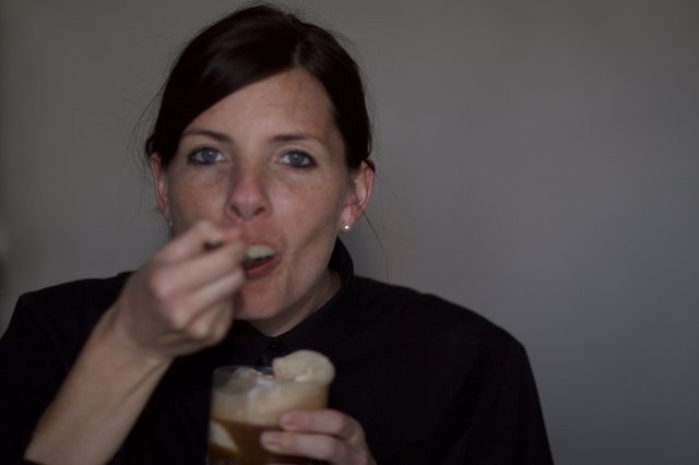 Woman Enjoying a Dessert Drink at Evening Gathering