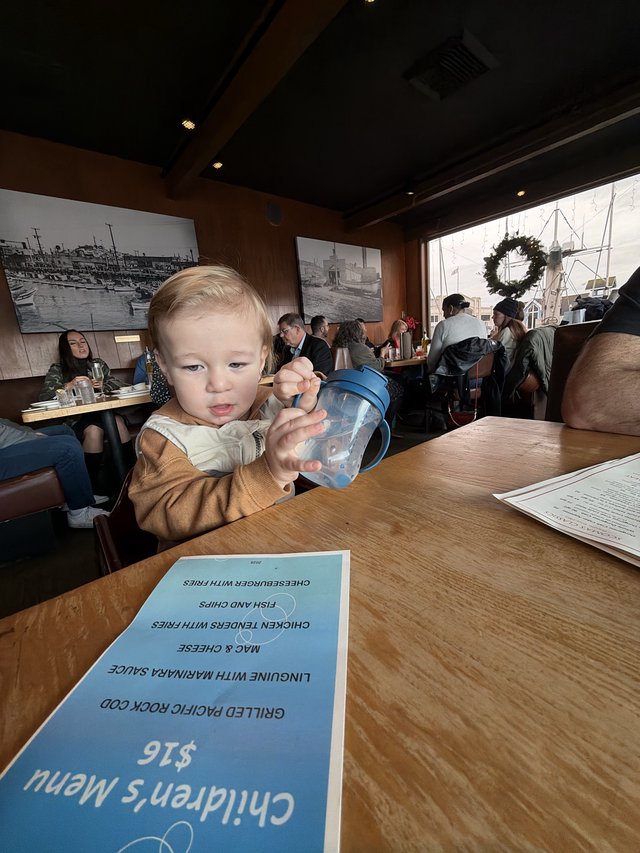 Young Child with Sippy Cup at Restaurant Table