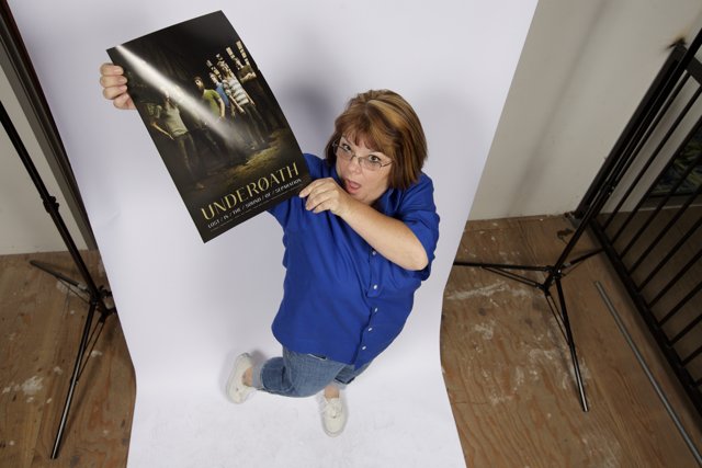 Woman Holds Poster Promoting Wood Flooring