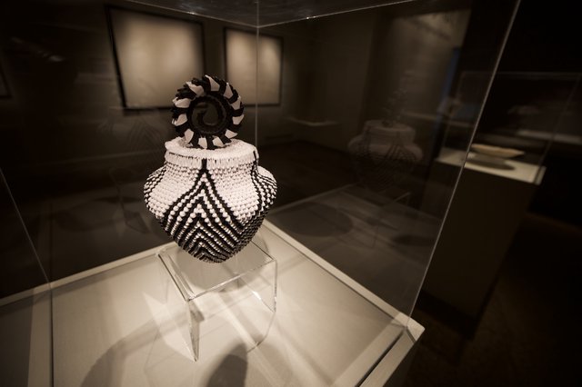 Traditional Beaded Vessel with Decorative Finial in Museum Display