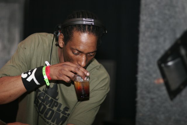 Dreadlocked man sipping from a glass