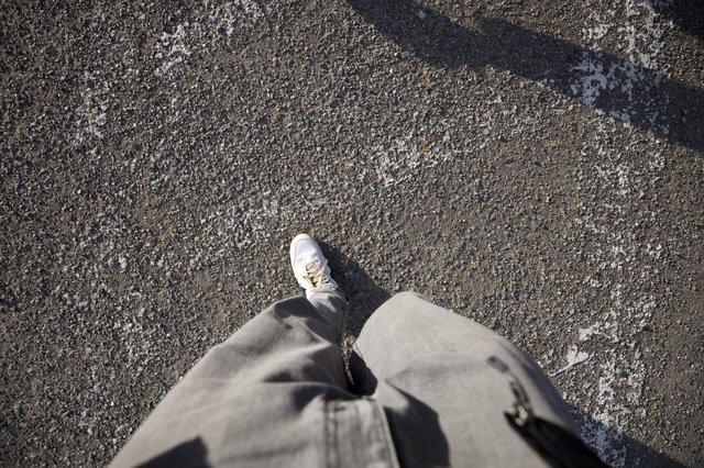 Point of View: Walking Alone on Weathered Asphalt