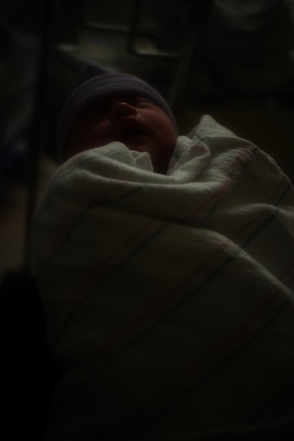 Newborn baby in beanie and blanket
