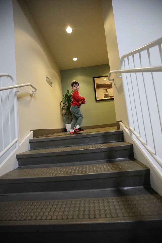 Young Boy Climbing Stairs in Modern Interior