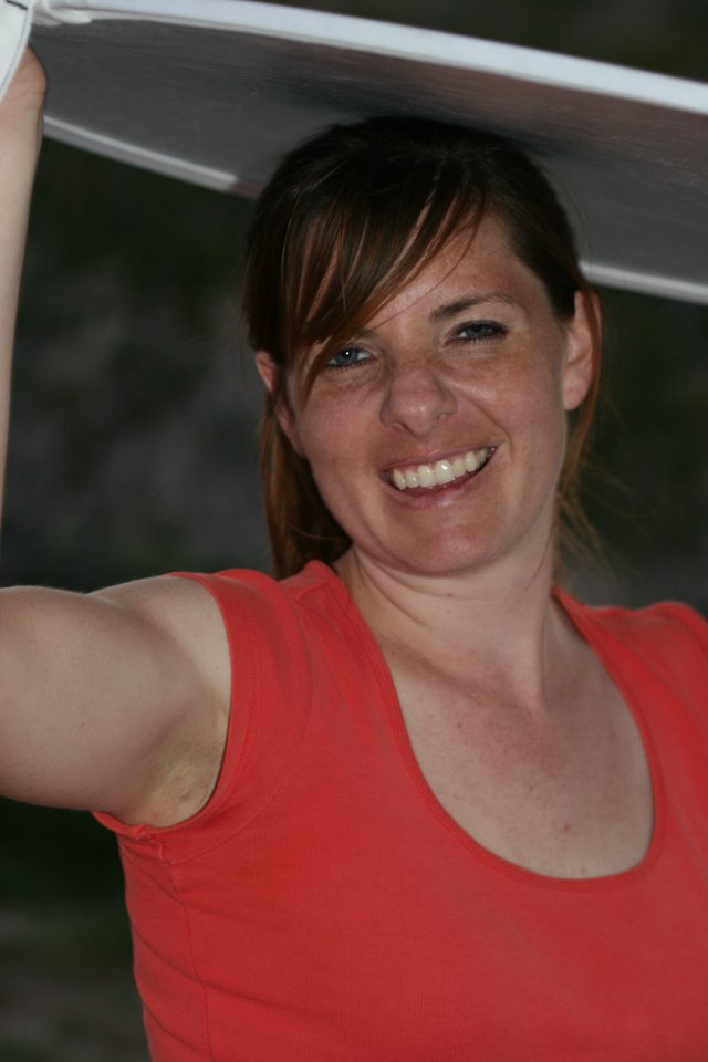 Joyful Woman Holding Up a White Panel Outdoors