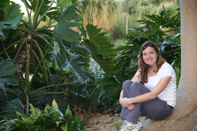 Woman Relaxing Among Lush Tropical Garden Foliage