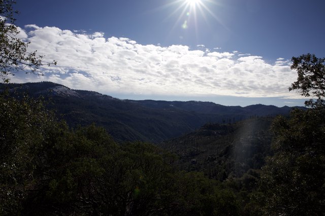 Sunburst Over Forested Mountain Valley in Winter