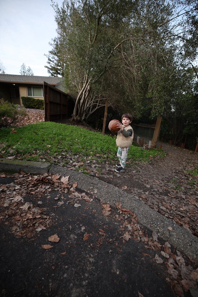 Young Child Playing Basketball in Suburban Driveway