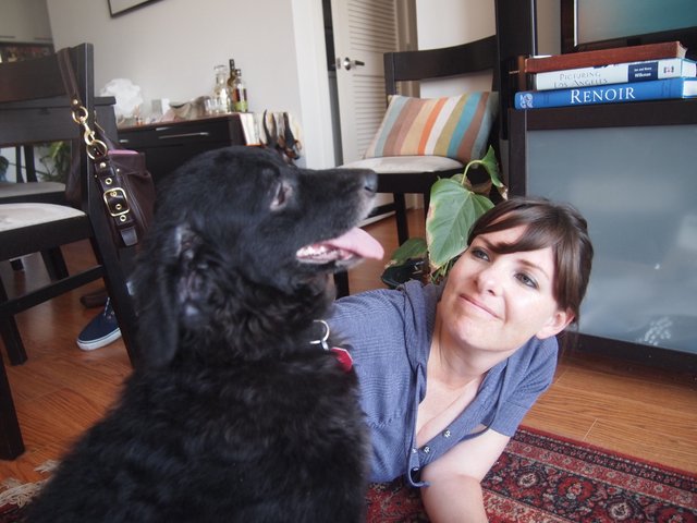 Woman and Black Dog Share a Playful Moment Indoors