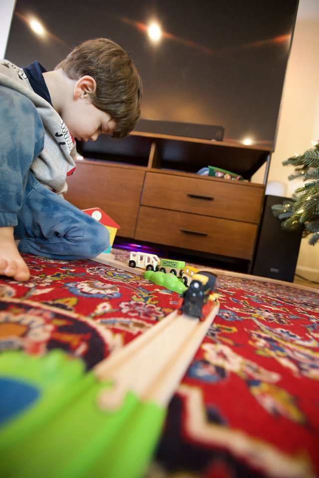 Child Playing with Wooden Train Set on Christmas