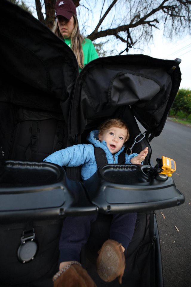 Curious Toddler's Wide-Eyed Wonder in Black Stroller