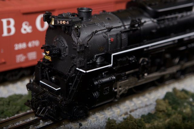 Black Locomotive and Red Train on Railway