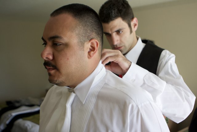 A Sharp Look Caption: Mark B adjusts his tie before heading out, looking sharp in his dress shirt and formal wear.